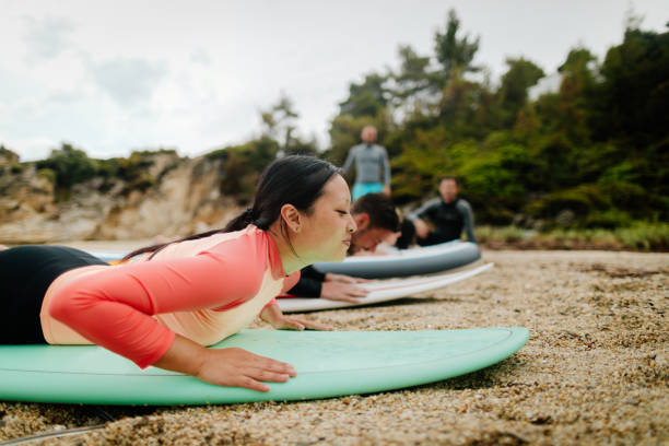 istock Beautiful young woman learning basics of surfing 1021326066