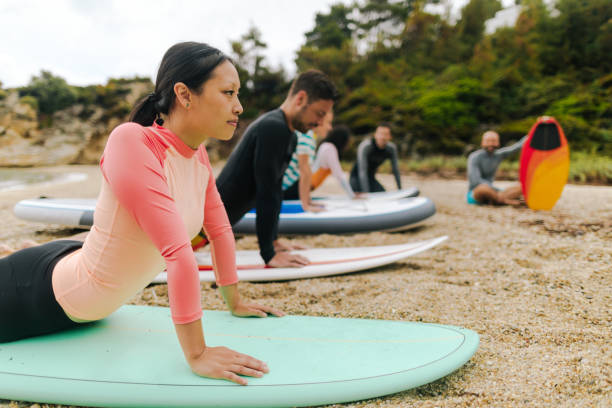 istock Beautiful young woman learning basics of surfing 1021326096