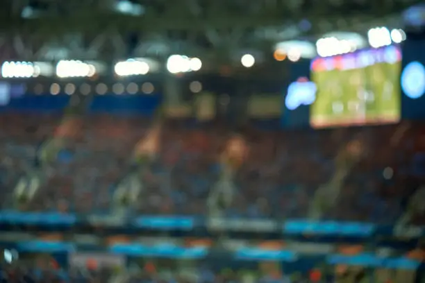 Photo of Full football soccer stadium field with lights. Soft focus blurred background