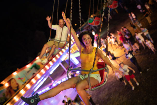 istock Happy young couple on carousel in amusement park 1021328536