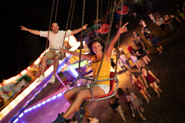istock Happy young couple on carousel in amusement park 1021328608