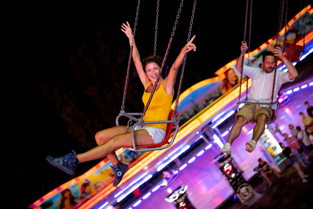 istock Happy young couple on carousel in amusement park 1021328654