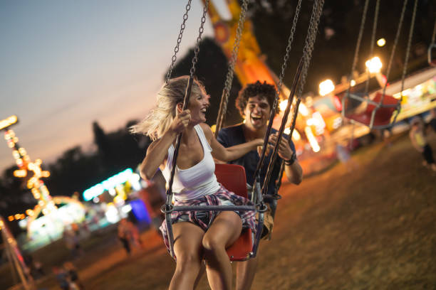 istock Happy young couple on carousel in amusement park 1021328772