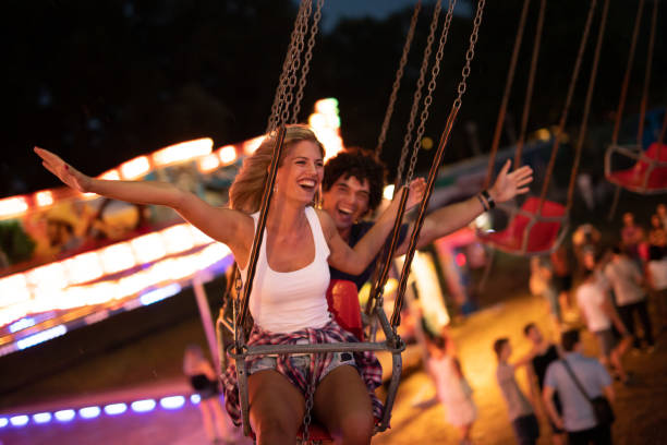 istock Happy young couple on carousel in amusement park 1021328804