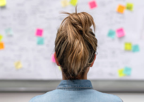 istock Creative business woman brainstorming at the office using a whiteboard 1021334602
