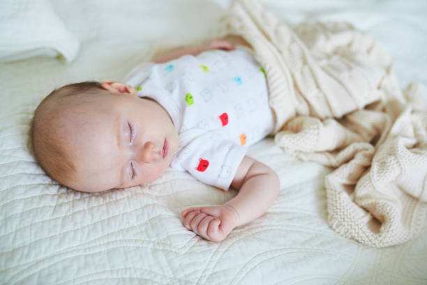 istock 3 months old baby girl sleeping under knitted blanket 1021355914