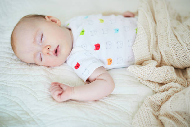 istock 3 months old baby girl sleeping under knitted blanket 1021356018