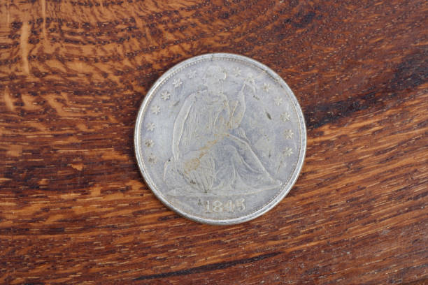 istock antique silver dollar on wooden background 1021356836