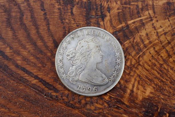 istock antique silver dollar on wooden background 1021359054