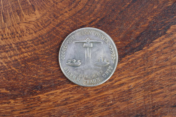 istock antique silver dollar on wooden background 1021359142