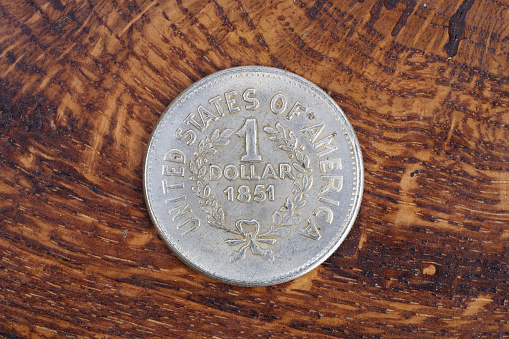 antique silver dollar on wooden background