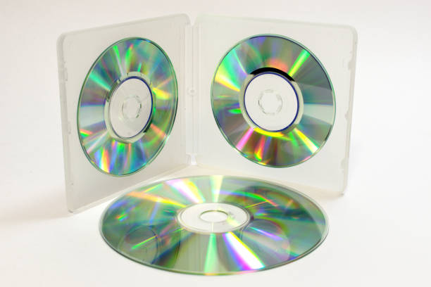 case for mini CDs; inner trays of double-sided semitransparent plastic box with iridescent discs on clips and normal sized disc is lying beside