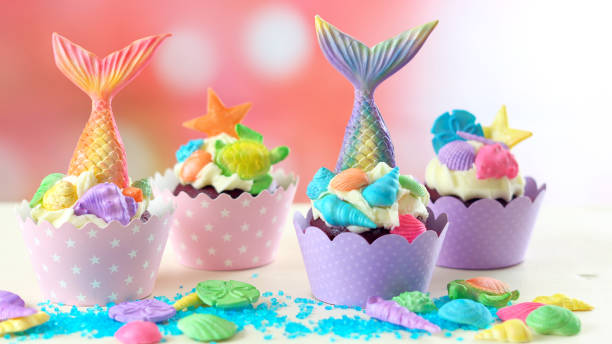 istock Mermaid theme cupcakes with colorful glitter tails, shells and sea creatures 1021365652