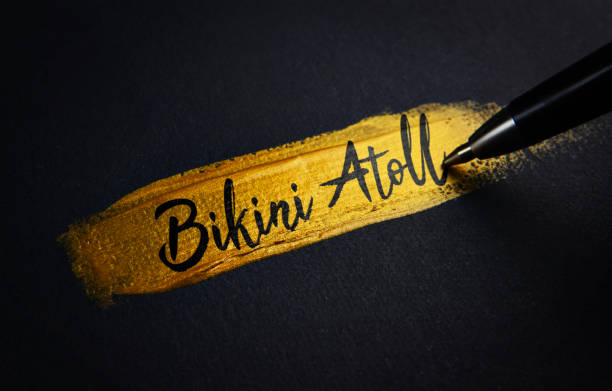 Bikini Atoll Handwriting Text on Golden Paint Brush Stroke Bikini Atoll Handwriting Text on Golden Paint Brush Stroke bikini atoll stock pictures, royalty-free photos & images