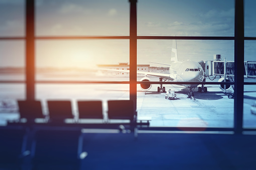 airplane waiting for departure in airport terminal, blurred horizontal background with place for text