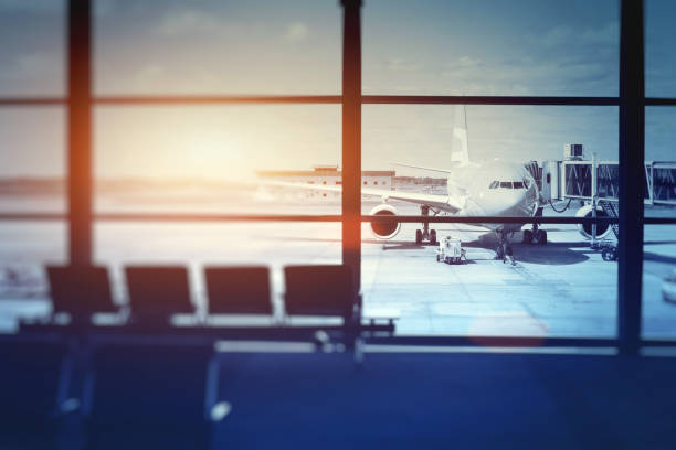 airplane waiting for departure in airport terminal airplane waiting for departure in airport terminal, blurred horizontal background with place for text airports stock pictures, royalty-free photos & images