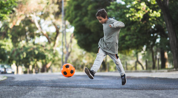 Boy play with football ball