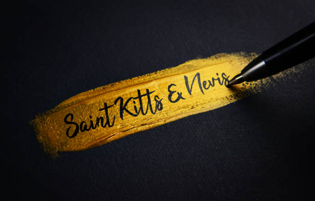 istock Saint Kitts and Nevis Handwriting Text on Golden Paint Brush Stroke 1021395094