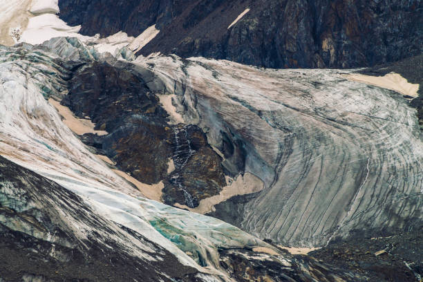 détaillée de texture naturelle du mont géant recouvert de neige et de glace. petits ruisseaux écoulement vers le bas de la montagne. rock avec image de gros yeux pleurant. diagonale neigeux. oeuvre de fantaisie de la nature majestueuse. - waterfall rock mountain bright photos et images de collection