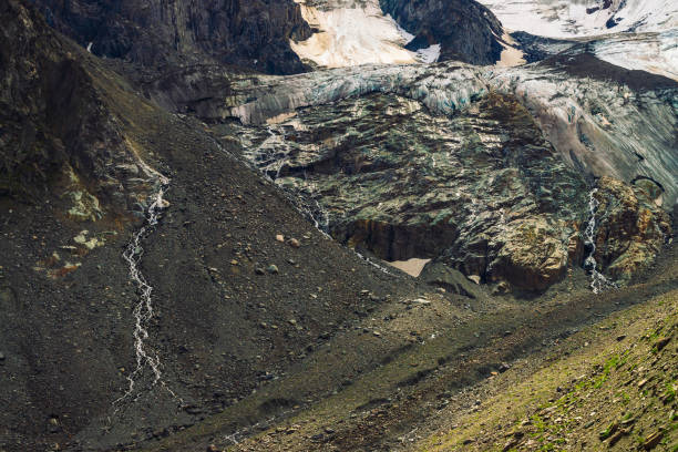 détaillée de texture naturelle du rocher géant de forme fantastique recouvert de neige et de glace dans les hautes terres. petites cascades et ruisseaux coule vers le bas de la montagne. paysage de montagne fantastique de la nature majestueuse. - waterfall rock mountain bright photos et images de collection