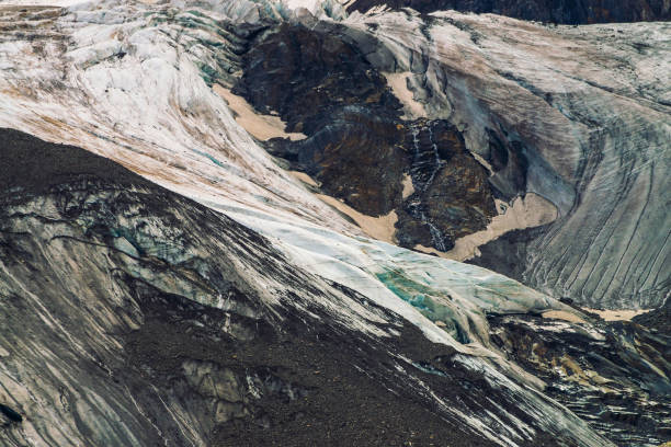 détaillée de texture naturelle du mont géant recouvert de neige et de glace. petits ruisseaux écoulement vers le bas de la montagne. rock avec image de gros yeux pleurant. diagonale neigeux. oeuvre de fantaisie de la nature majestueuse. - waterfall rock mountain bright photos et images de collection