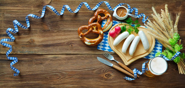 Bavarian sausages with pretzels, sweet mustard and beer on rustic wooden table Bavarian sausages with pretzels, sweet mustard and beer on rustic wooden table. Beer Fest menu weisswurst photos stock pictures, royalty-free photos & images