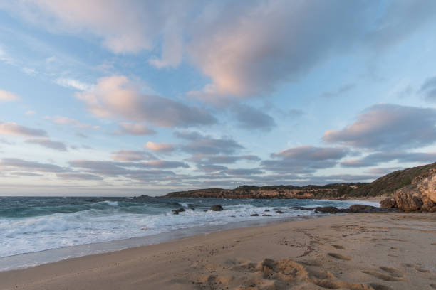 istock sunrise over the beach with waves crashing and clouds above 1021425372