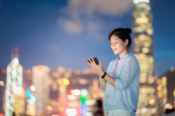 istock Young woman using smartphone at night 1021468560