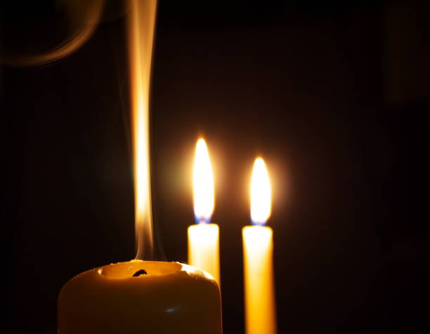 istock extinguished candle in front of two burning ones, macro 1021471652