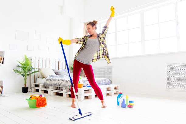 istock Woman in protective gloves is smiling and wiping dust using a spray and a duster 1021495022