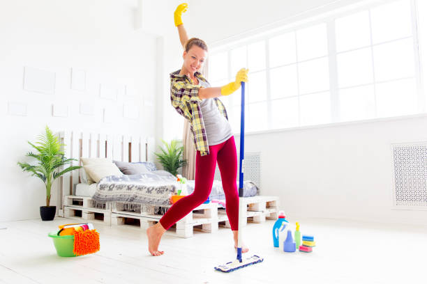 istock Woman in protective gloves is smiling and wiping dust using a spray and a duster 1021495046