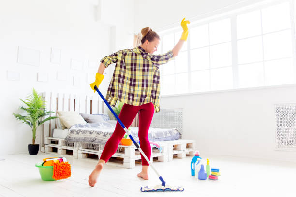 istock Woman in protective gloves is smiling and wiping dust using a spray and a duster 1021495070