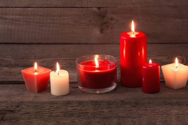istock red and white candles on dark wooden background 1021497820