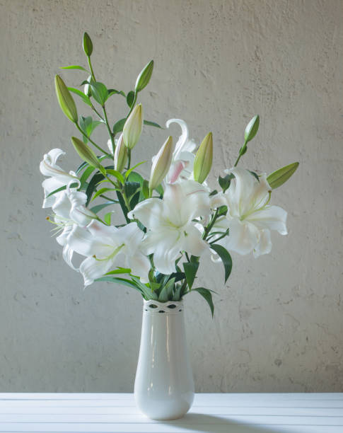 istock beautiful white lily in vase on background old wall 1021497838