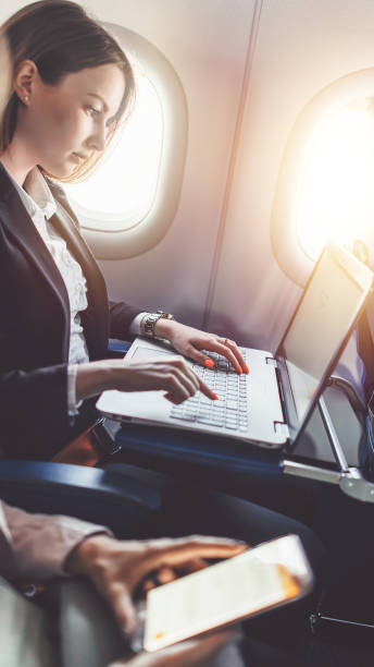 istock Female businesswoman is working on her project using a laptop while sitting in a plane 1021502670