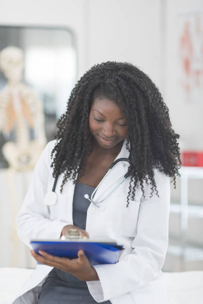 istock Female African American doctor going over patient notes on a clipboard 1021505380