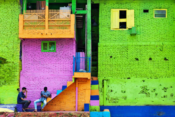 mensen lopen in kleurrijke huizen dorp jodipan kampung kleur warni - malang stockfoto's en -beelden