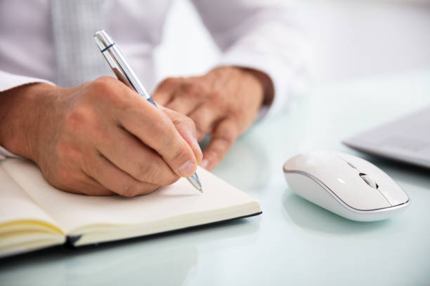 istock Businessperson Writing Schedule In Diary With Pen 1021542896