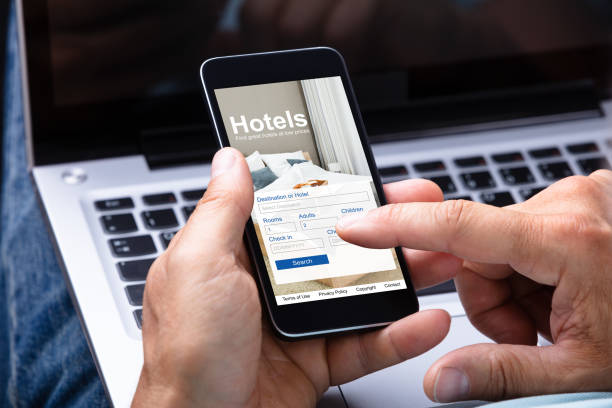 Man Booking Hotel Using Smartphone Close-up Of A Man's Hand Booking Hotel Using Smartphone reservation stock pictures, royalty-free photos & images