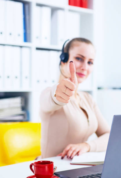 istock Cheerful smiling female customer service operator showing thumbs up in office 1021543782