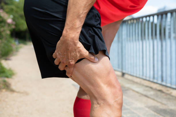Runner Holding His Injured Leg Close-up Of A Male Runner Holding His Injured Leg hamstring injury stock pictures, royalty-free photos & images