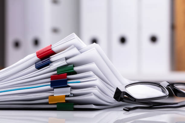 stacked documents and eyeglasses - stack paperwork paper document imagens e fotografias de stock