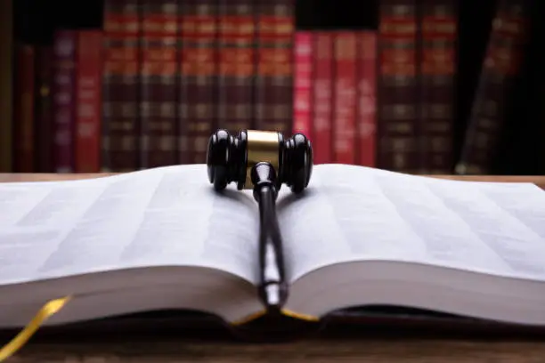 Close-up Of An Open Law Book And Wooden Mallet In Courtroom