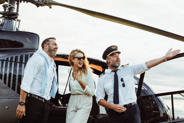 Smiling couple by a private helicopter with pilot