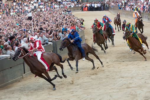 Siena, Italy - August 16, 2018: Riders compete in the famous horse race 'Palio di Siena', in the medieval square \