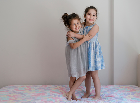 Boy and girl hugging each other on white background. Happy young kids. Portrait of brother and sister having fun. Two children's friendship.