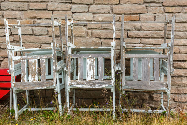 istock Old stacked left over garden chairs by a wall 1021577486