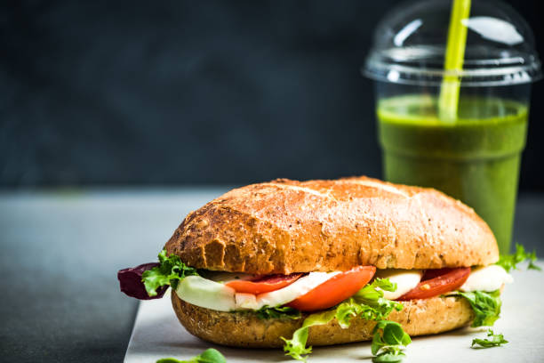 Healthy sandwich bun with green smoothie stock photo