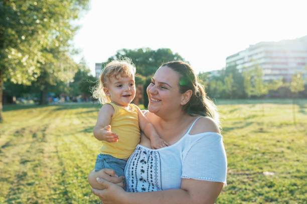 istock Overweight mother hugging her son outdoors 1021605430