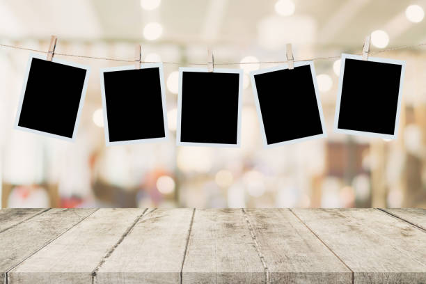 Empty wood table and instant photo hanging on blur image background of people display montage for product. Empty wood table and instant photo hanging on blur image background of people display montage for product. clothesline photos stock pictures, royalty-free photos & images
